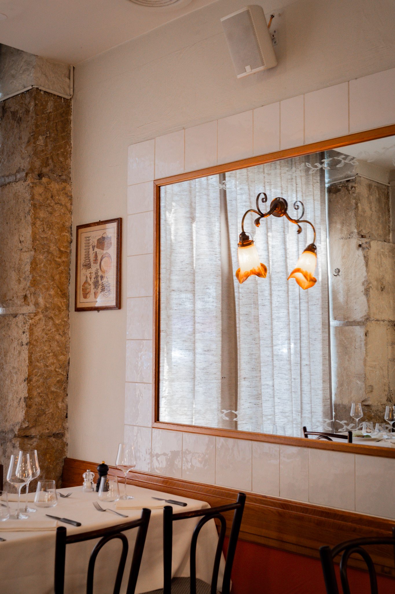 The dining room, its mirrors and wall lights
